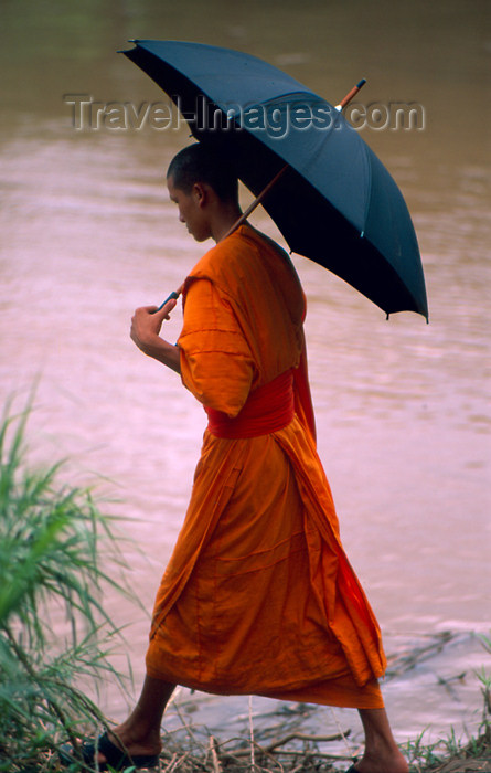 laos57: Laos - Luang Prabang / Louangphrabang - Monk with umbrella walks along the Mekong River (photo by K.Strobel) - (c) Travel-Images.com - Stock Photography agency - Image Bank