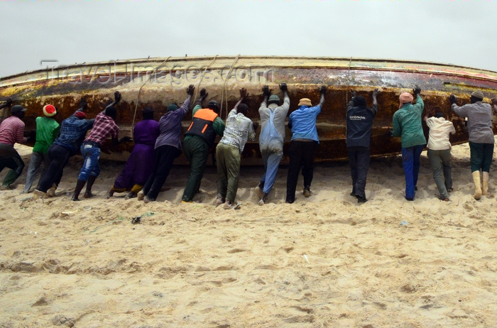 mauritania32: Nouakchott, Mauritania: men roll manually a fishing boat - fishing harbor, the Port de Pêche - photo by M.Torres - (c) Travel-Images.com - Stock Photography agency - Image Bank