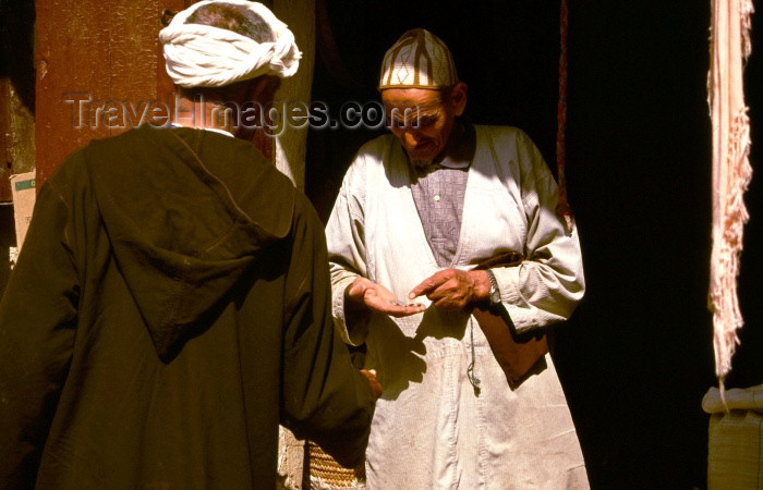 moroc103: Morocco / Maroc - Fès: merchant in the medina - checking a payment - man wearing a jallaba - photo by F.Rigaud - (c) Travel-Images.com - Stock Photography agency - Image Bank