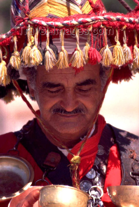 moroc113: Morocco / Maroc - Marrakesh / Marrakech / Marraquexe: water seller with spectacular hat and and bronze cups around his neck - Berber hat - Moroccan hat - photo by F.Rigaud - (c) Travel-Images.com - Stock Photography agency - Image Bank