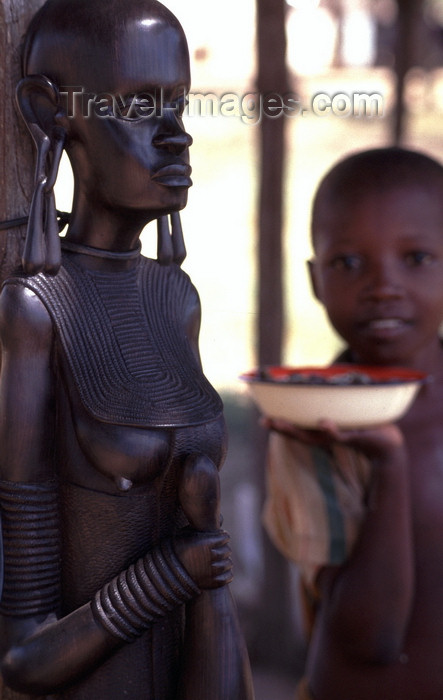 mozambique193: Pemba / Porto Amélia, Cabo Delgado, Mozambique / Moçambique: large Maconde sculpture and kid with bowl / escultura maconde e rapaz com tigela - photo by F.Rigaud - (c) Travel-Images.com - Stock Photography agency - Image Bank