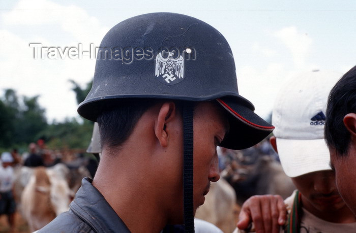 myanmar233: Myanmar - Heho - Shan State: man with in the market with German Wehmacht helmet - Stahlhelm - photo by W.Allgöwer - Ein junger Burmese trägt die Nachbildung eines Wehrmachtshelms auf dem Wasserbüffel-Markt. Der Markt in Heho findet alle fünf Tage statt. E - (c) Travel-Images.com - Stock Photography agency - Image Bank