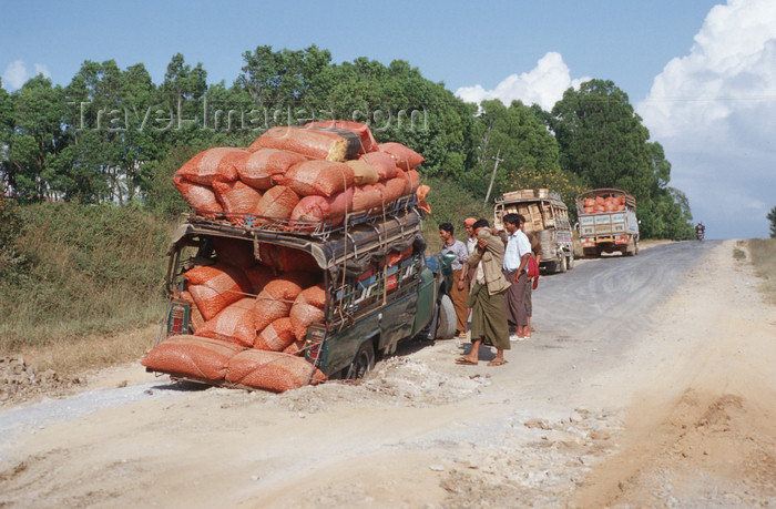 myanmar255: Myanmar - hazardous road - truck in a pot hole - photo by W.Allgöwer - Auf den oftmals unbefestigten Strassen in Myanmar ist ein total überladener Pickup in ein Schlagloch geraten und hat Achsbruch erlitten, - (c) Travel-Images.com - Stock Photography agency - Image Bank
