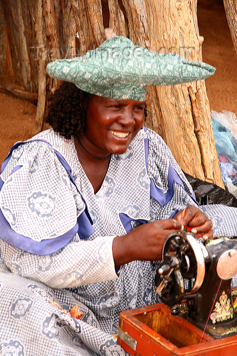 namibia227: Kunene region, Namibia: Herero woman making souvenier dolls - Namibian hat - sewing machine - photo by Sandia - (c) Travel-Images.com - Stock Photography agency - Image Bank