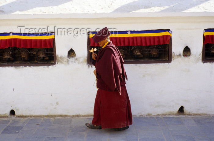 nepal287: Kathmandu valley, Nepal: Bodhnath temple complex - Buddhist ritual - turning the wheel of Dharma - monk with mani wheel walks along a wall with prayer wheels - photo by W.Allgöwer - (c) Travel-Images.com - Stock Photography agency - Image Bank