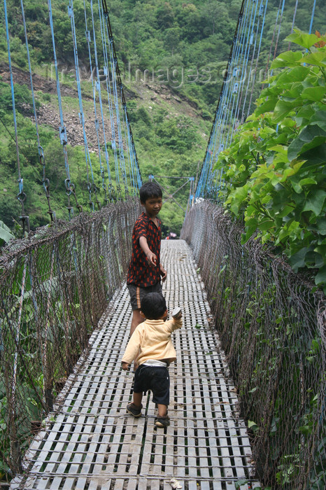 nepal314: Annapurna region, Nepal: kids crossing a suspension bridge - photo by M.Wright - (c) Travel-Images.com - Stock Photography agency - Image Bank