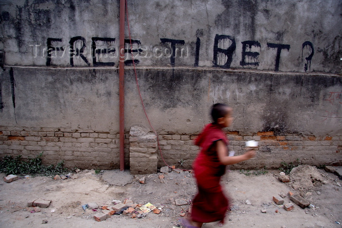 nepal4: Kathmandu, Nepal: 'Free Tibet' graffiti and passing Tibetan monk - photo by G.Koelman - (c) Travel-Images.com - Stock Photography agency - Image Bank