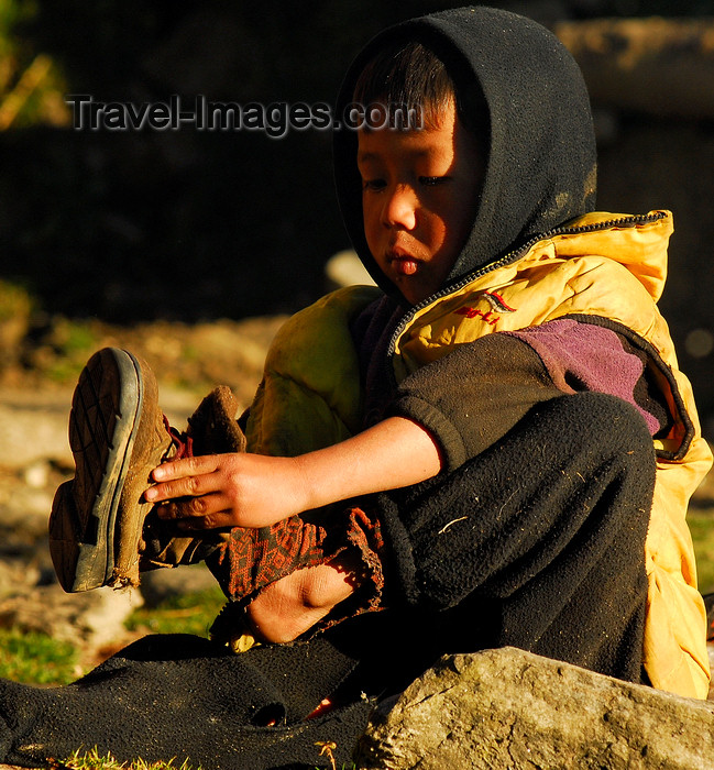 nepal436: Sankhuwasabha District, Kosi Zone, Nepal: boy with thorn socks puts on his shoes - photo by E.Petitalot - (c) Travel-Images.com - Stock Photography agency - Image Bank