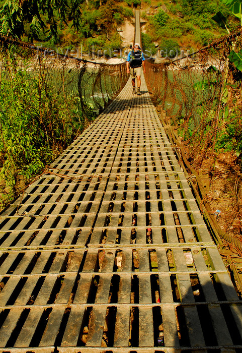 nepal441: Sankhuwasabha District, Kosi Zone, Nepal: trekker crossing the Arun river on a suspension  bridge - photo by E.Petitalot - (c) Travel-Images.com - Stock Photography agency - Image Bank