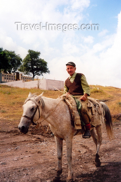 nk12: Nagorno Karabakh - Dirimbon: rough rider - cowboy, Caucasus style - war memorial in the background (photo by M.Torres) - (c) Travel-Images.com - Stock Photography agency - Image Bank