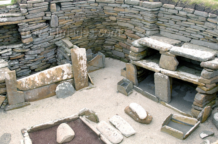 orkney28: Orkney island - Skara Brae - View of House #1 at Skara Brae.  From right to left are the stone dresser where prize objects were stored and displayed, next we have a box bed, lower center is the hearth, and in front of the dresser are containers for prepar - (c) Travel-Images.com - Stock Photography agency - the Global Image Bank