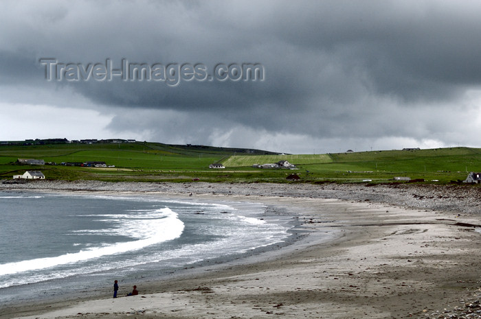 orkney30: Orkney island - Skara Brae - Two boys play in the sand oblivious to the waves and storm rolling in. The beach at Skara Brae. - (c) Travel-Images.com - Stock Photography agency - the Global Image Bank