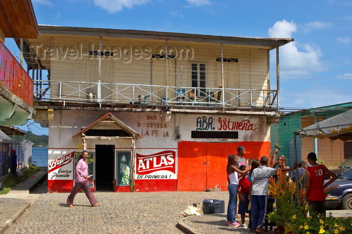 panama289: A group of kids chat as an adult passes by, in front of a small town saloon. Portobello, Colon, Panama, Central America - photo by H.Olarte - (c) Travel-Images.com - Stock Photography agency - Image Bank