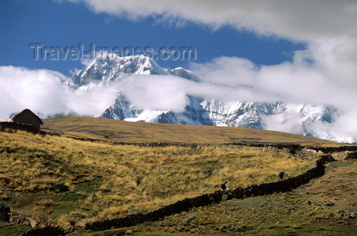 peru142: Ausangate massif, Cuzco region, Peru: hikers cross a farm on the high Altiplano below the mighty Andean peak of Ausangate - Peruvian Andes - Cordillera Blanca - photo by C.Lovell - (c) Travel-Images.com - Stock Photography agency - Image Bank