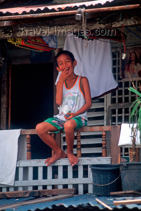 phil23: Manila city, Philippines - happy boy with Jesus icon - Slums and shanty towns - photo by B.Henry - (c) Travel-Images.com - Stock Photography agency - Image Bank