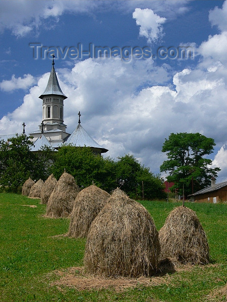 romania76: Gura Humorului, Suceava county, southern Bukovina, Romania: church and haystacks - rural landscape - photo by J.Kaman - (c) Travel-Images.com - Stock Photography agency - Image Bank