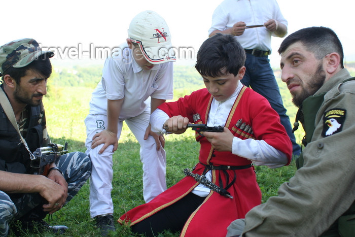 russia772: Chechnya, Russia - boy assembling a pistol - wearing Chechen national costume with a dagger - photo by A.Bley - (c) Travel-Images.com - Stock Photography agency - Image Bank