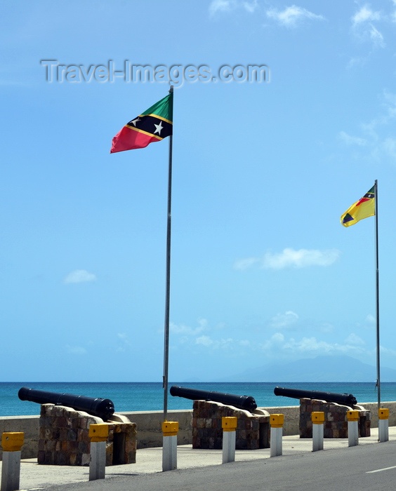 saint-kitts-nevis63: Charlestown, Nevis, St Kitts and Nevis: old British naval guns aimed at the sea on Low Street, country and island flags - photo by M.Torres - (c) Travel-Images.com - Stock Photography agency - Image Bank