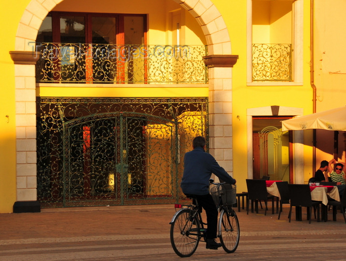 sardinia245: Pula, Cagliari province, Sardinia / Sardegna / Sardigna: cyclist and elaborate iron gate - Piazza del Popolo - Via Nora - photo by M.Torres - (c) Travel-Images.com - Stock Photography agency - Image Bank