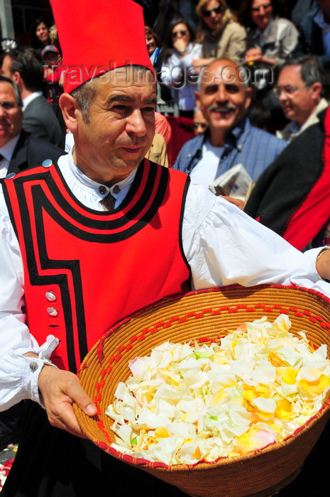 sardinia395: Cagliari, Sardinia / Sardegna / Sardigna: Feast of Sant'Efisio / Sagra di Sant'Efisio - man with a basket of rose petals for the 'Sa Ramadura' ritual - red coat of the militia, who in antiquity protected the procession from bandits along the coastal road - procession organised by the Arciconfaternita del Gonfalone - photo by M.Torres - (c) Travel-Images.com - Stock Photography agency - Image Bank