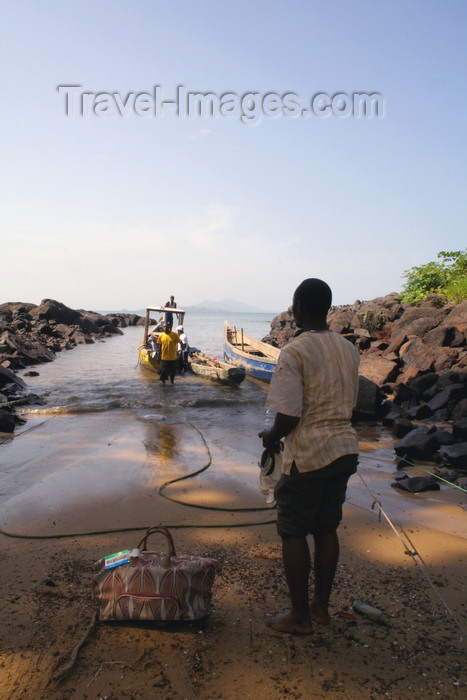 sierra-leone8: Kent, Freetown Peninsula, Sierra Leone: boat taxi - client with luggage waits on the beach - photo by J.Britt-Green - (c) Travel-Images.com - Stock Photography agency - Image Bank