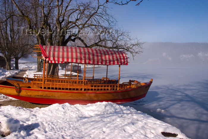 slovenia189: Slovenia - View across to the island church on Lake Bled when frozen over in winter with Pletna boat moored in front - Blejsko jezero - photo by I.Middleton - (c) Travel-Images.com - Stock Photography agency - Image Bank