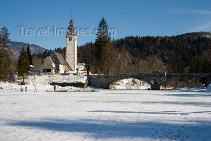 slovenia222: Slovenia - Ribcev Laz - People walking and ice skating on Bohinj Lake when frozen over - Church of St John the Baptist and stone bridge - photo by I.Middleton - (c) Travel-Images.com - Stock Photography agency - Image Bank