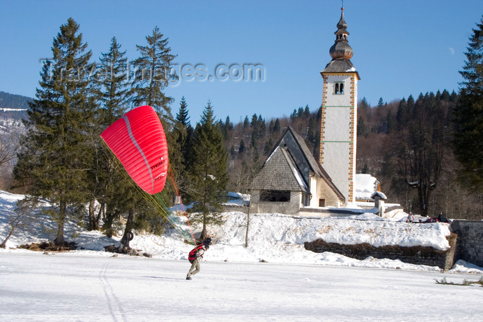 slovenia224: Slovenia - Ribcev Laz - man preparing to paraglide across a frozen Bohinj Lake - St John's church in the background - photo by I.Middleton - (c) Travel-Images.com - Stock Photography agency - Image Bank