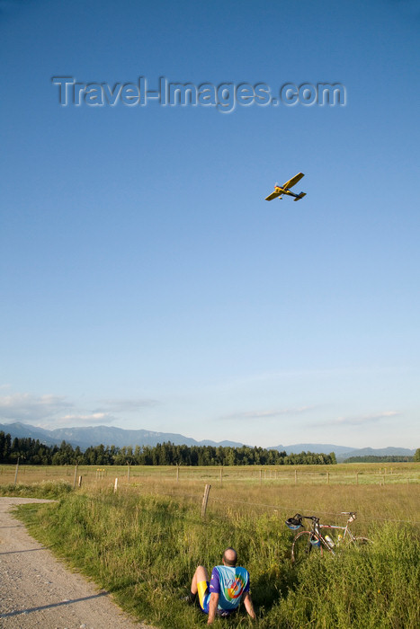 slovenia610: Slovenia - Brnik Airport: Bulldog Air S5-DEH Cessna 152 aircraft landing at Ljubljana Joze Pucnik Airport - cyclist watching - plane spotting - photo by I.Middleton - (c) Travel-Images.com - Stock Photography agency - Image Bank