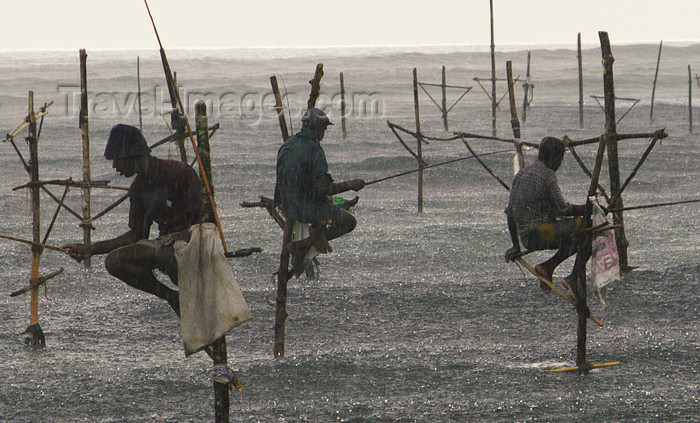 sri-lanka117: Sri Lanka Three stilt fishermen in the rain, Weligama (photo by B.Cain) - (c) Travel-Images.com - Stock Photography agency - Image Bank