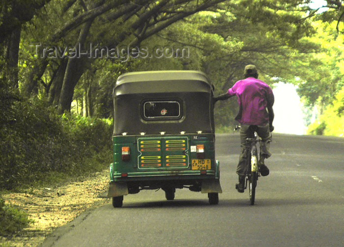 sri-lanka120: Kandy district, Central Province, Sri Lanka: auto rickshaw / tuk-tuk & hitcher on a bike, near Kandy - photo by B.Cain - (c) Travel-Images.com - Stock Photography agency - Image Bank