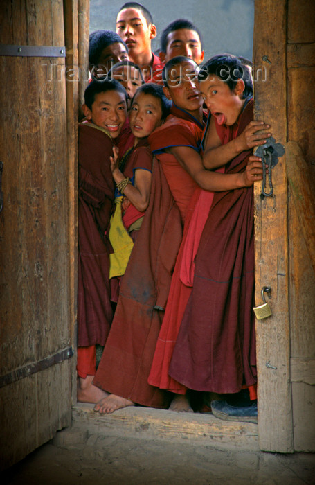 tibet91: Lhasa, Tibet - childish novices on a door - Buddhist monks - photo by Y.Xu - (c) Travel-Images.com - Stock Photography agency - Image Bank