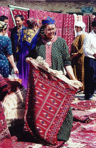 turkmenistan10: Turkmenistan - Ashghabat: Turkmen carpets at the market - ldy with rug - photo by G.Frysinger - (c) Travel-Images.com - Stock Photography agency - Image Bank