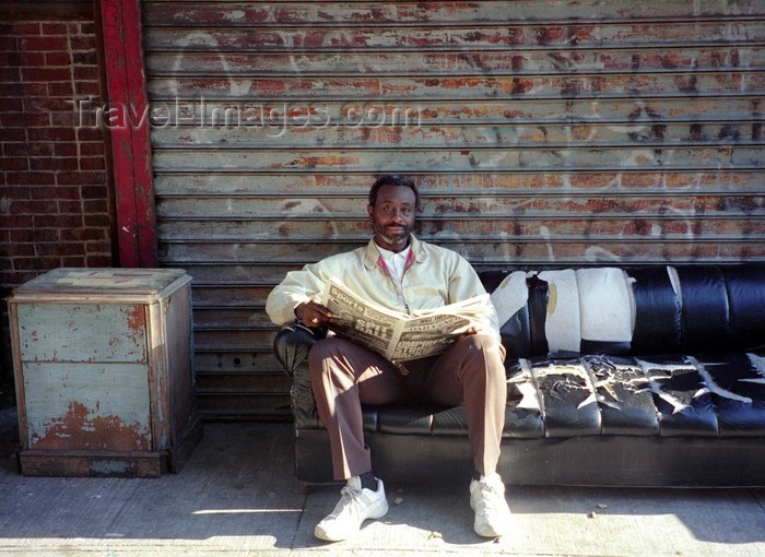 usa239: Harlem, New York, USA: man using steet furniture for reading the newspaper - photo by J.Kaman - (c) Travel-Images.com - Stock Photography agency - Image Bank