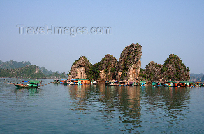 vietnam129: Halong Bay - Vietnam: fishing boat passing a floating village - photo by Tran Thai - (c) Travel-Images.com - Stock Photography agency - Image Bank