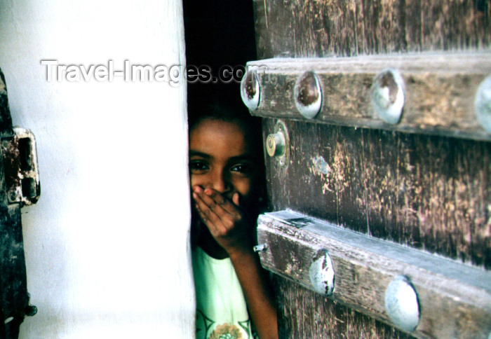 yemen21: Seyun, Hadhramaut Governorate, Yemen: girl behind door, hiding her laughter - photo by N.Cabana - (c) Travel-Images.com - Stock Photography agency - Image Bank