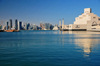 Doha, Qatar: Museum of Islamic Art reflected on the bay and the West Bay skyscrapers - photo by M.Torres