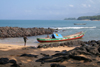 Kent, Sierra Leone: fishing boat in rocks blue sea and sky - photo by J.Britt-Green