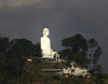 Kandy, Central Province, Sri Lanka: white hillside Buddha against a dark sky - concrete Buddha - photo by B.Cain