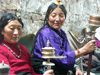 Tibet - Lhasa: Tibetan women in colourful dress spinning prayer wheels - photo by P.Artus