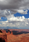 Canyonlands National Park, Utah, USA: buttes, mesas, rock pillars and clouds - Shafer Canyon from Island in the Sky district - La Sal mountains, part of the Rockies, in the background - photo by M.Torres