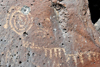 Albuquerque, Bernalillo County, New Mexico, USA: Petroglyph National Monument - Rinconada Canyon trail - bullet-damaged spiral - petroglyph made by pecking the basalt - photo by M.Torres