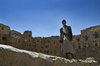 Hababah, Sana'a governorate, Yemen: young man standing on wall in front of Old Town buildings - photo by J.Pemberton
