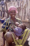 Cte d'Ivoire - Smiling lady and her baby - breast feeding outdoors (photo by J.Filshie)