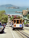 San Francisco (California): a tram climbs a hill - Alcatraz in the background  - tram line nr 19 - Powel and Market (photo by M.Bergsma)